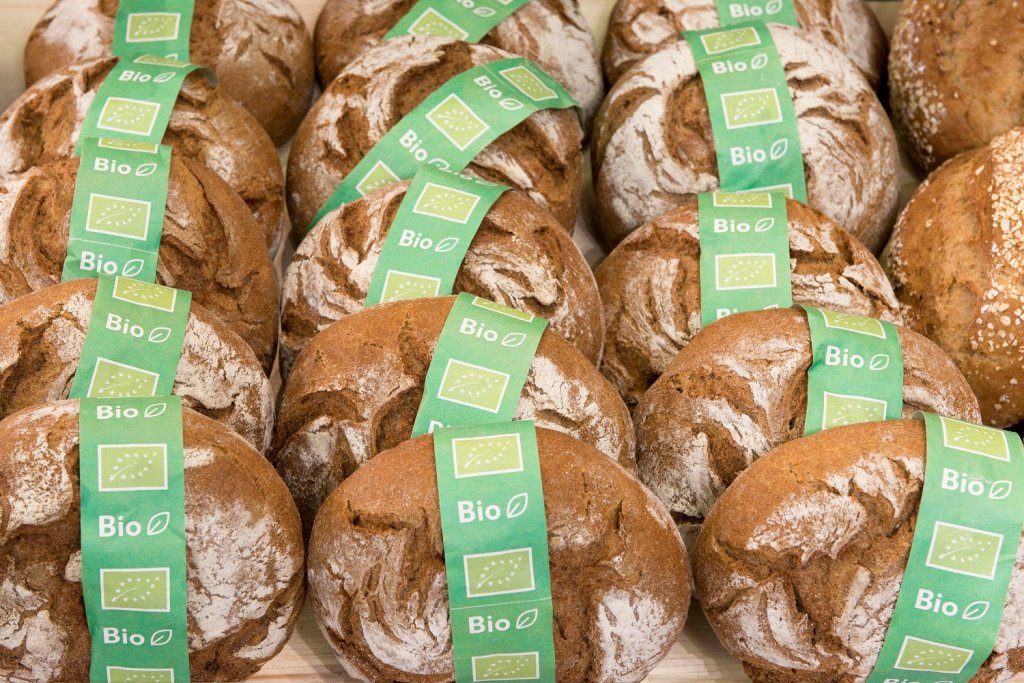 Mehrere Brote mit Bio-Label liegen in der Auslage einer Bäckerei.