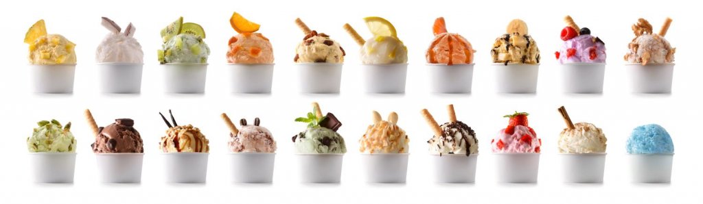 Verschiedene, schön dekorierte Eiskreationen. Dargeboten werden diese in einem Eisschälchen aus Pappe.